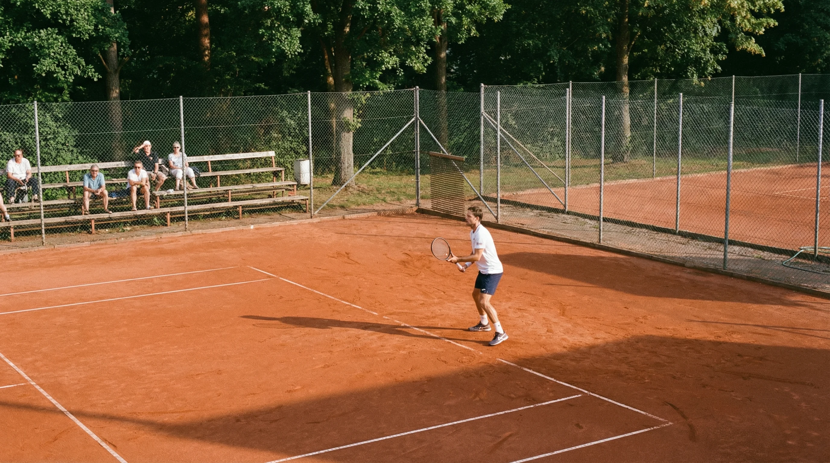 Kleiner Tennisplatz mit wenigen Zuschauern bei einem Challenger-Turnier im Freien