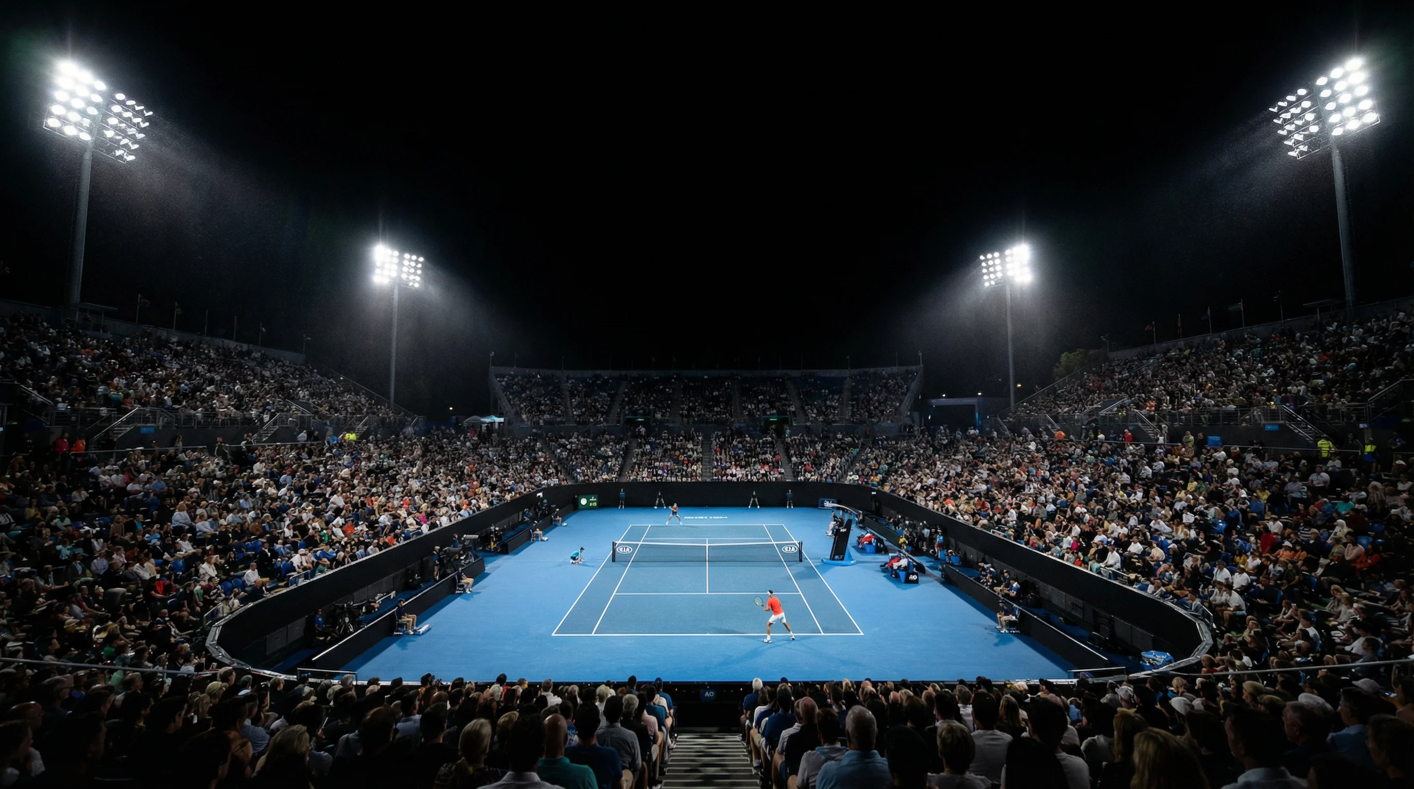 Beleuchteter Tennisplatz bei Nacht unter Flutlicht mit Zuschauertribüne
